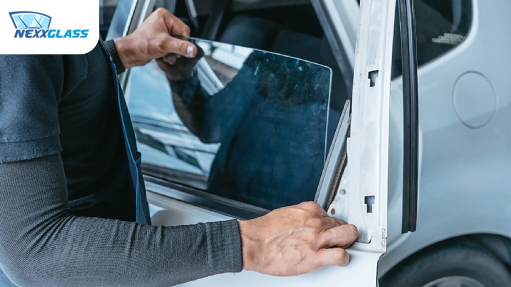 Technicien installant une vitre latérale dans une portière de voiture, par NEXXGLASS